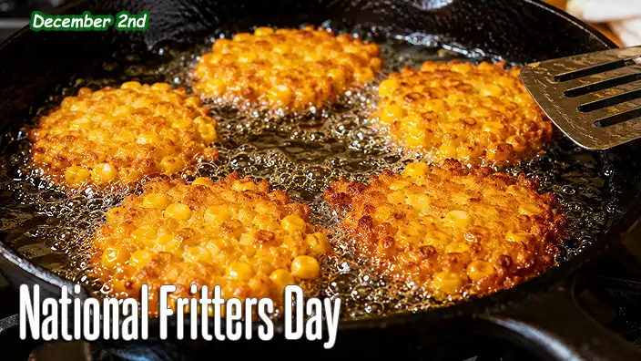 Fresh corn fritters sizzle in hot oil in a black cast-iron pan, with a metal spatula nearby and golden-brown surfaces showing a perfectly crisp texture.
