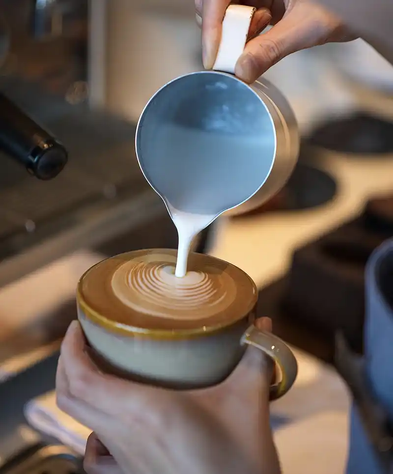Hot Milk being added to Cappuchino by a professional Barista