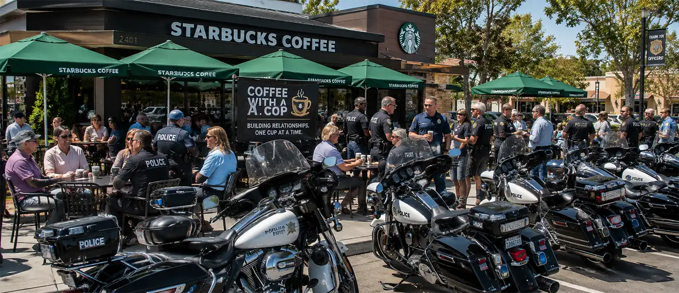 Police motorcycles are parked outside a busy Starbucks where officers and community members enjoy coffee and conversation during a successful Coffee with a Cop event.
